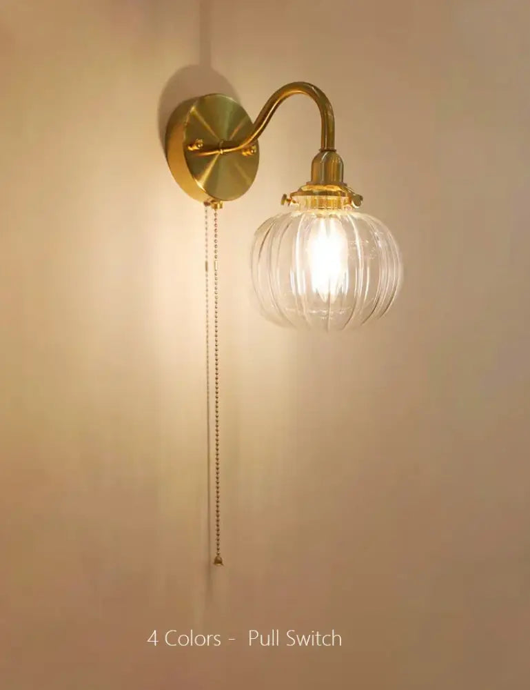 Vintage brass wall sconce lamp with ribbed glass globe and pull chain switch ideal for bedroom lighting