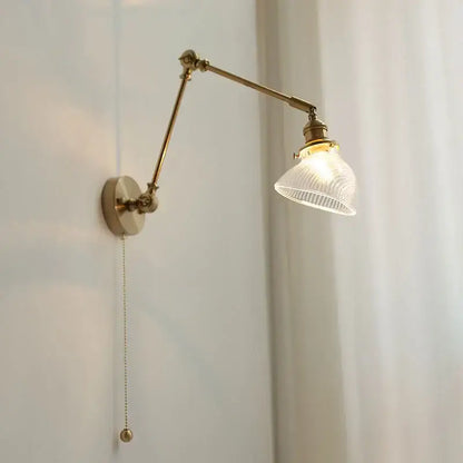 Antique brass adjustable vintage wall light fixture with ribbed glass shade and pull-chain switch for bedroom use