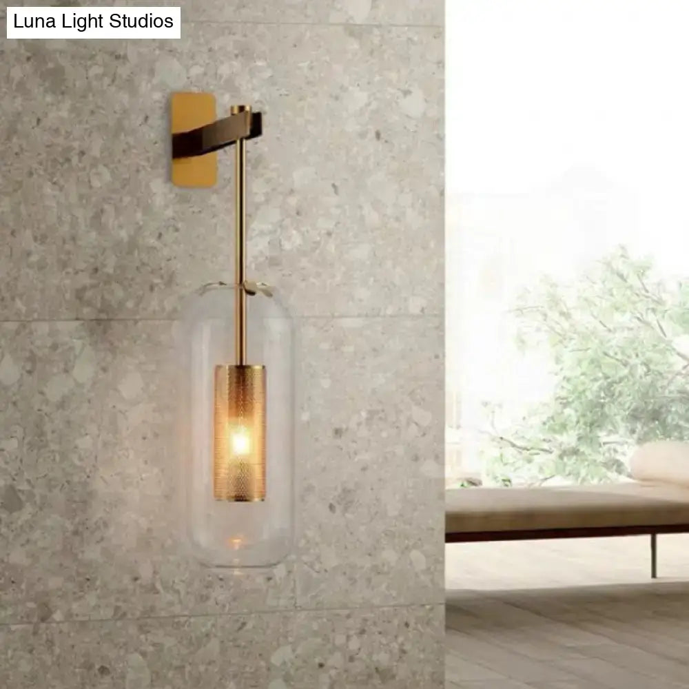 A vintage brass wall lamp with a clear glass cylinder shade and illuminated glass cylinder for living room use