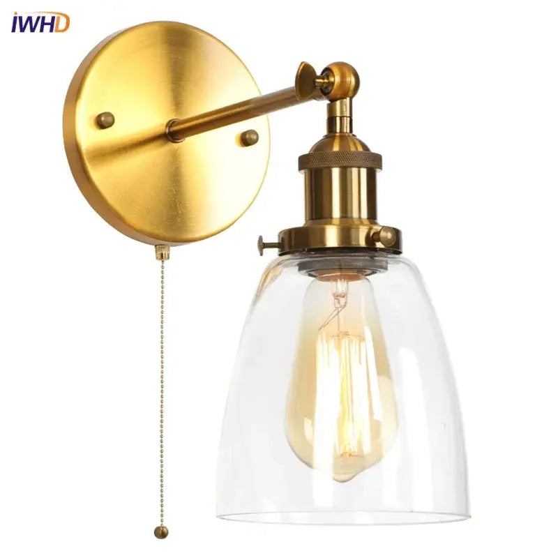 Vintage brass wall light fixture with clear glass dome and exposed filament bulb for bedroom lighting