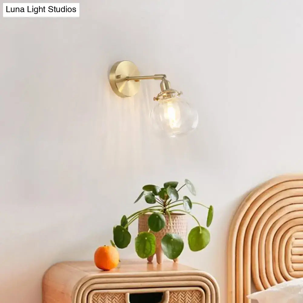 Vintage brass wall light with gold-toned champagne clear glass shade designed for bedroom use