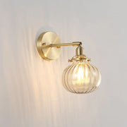 Vintage brass wall light with champagne clear ribbed glass shade and exposed filament bulb for bedroom use
