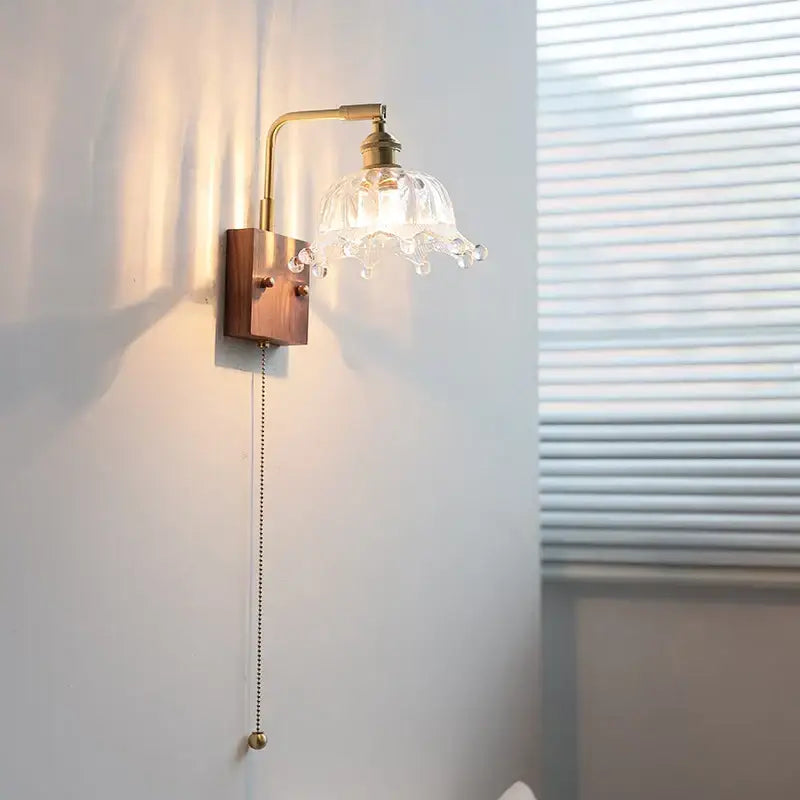 Vintage brass wall light with clear glass flower-shaped lampshade and dangling crystal droplets for bedroom decorbites clear glass