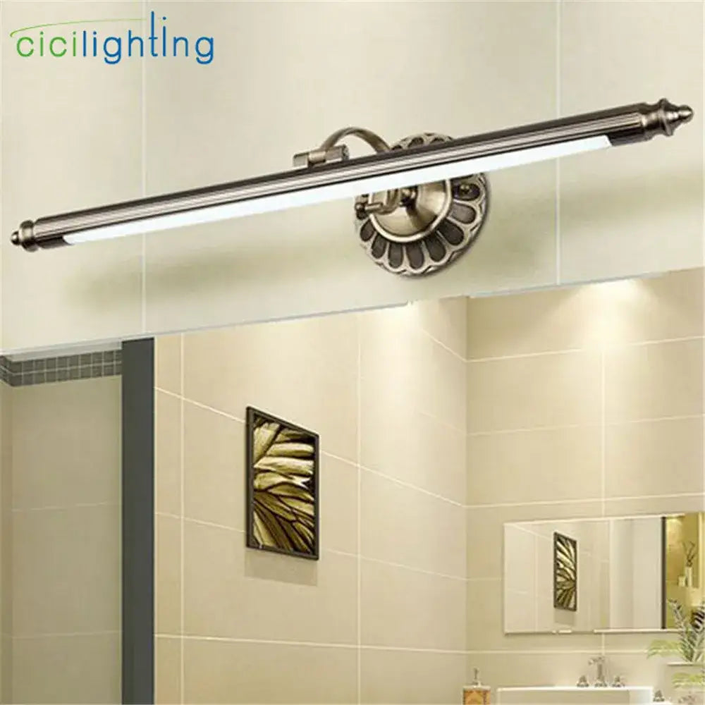 Brass-finished vintage bronze led bathroom wall lamp with sleek elongated design and ornate fluted circular mounting plate decorbites bronze led