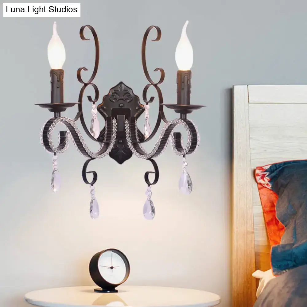 Antique bronze two-light wall mounted lamp with crystal teardrop pendants and candle-style bulbs for living room