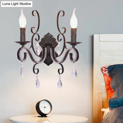 Antique bronze two-light wall mounted lamp with crystal teardrop pendants and candle-style bulbs for living room