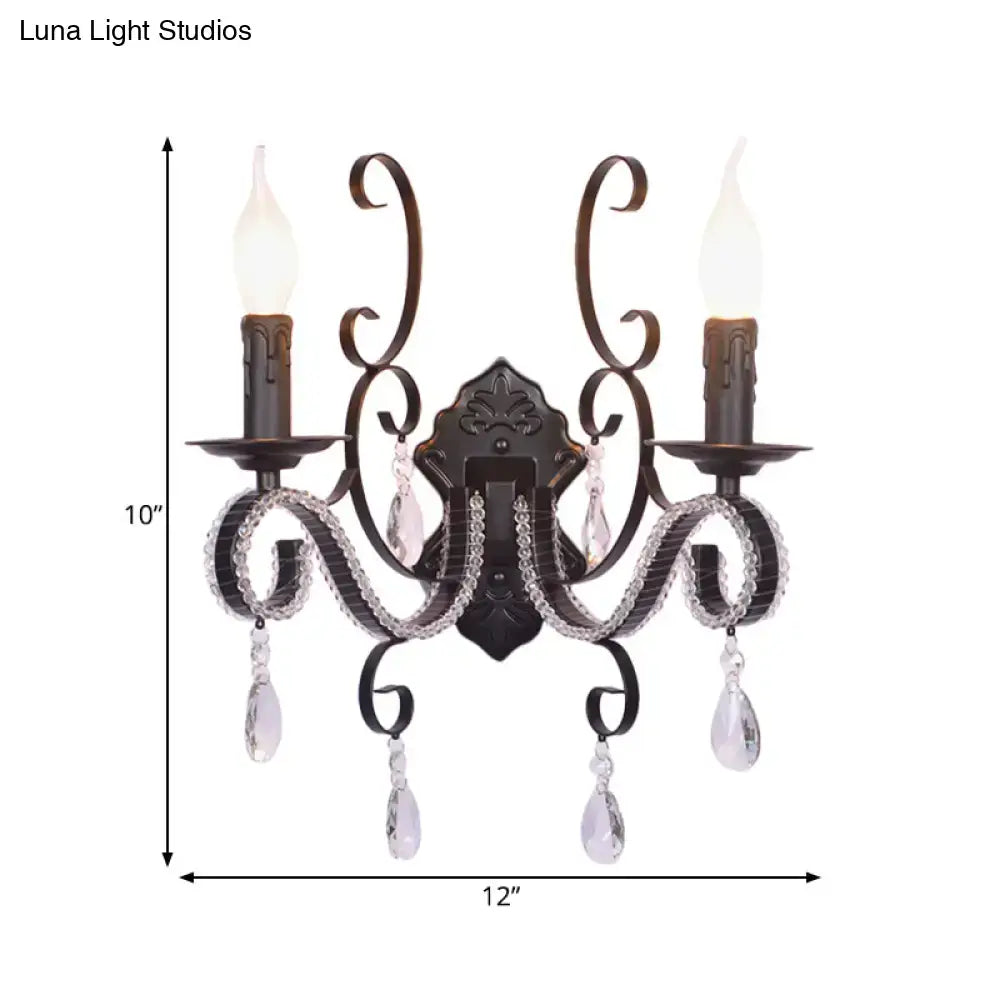 Antique bronze two-light wall mounted lamp with crystal teardrop pendants and candle-style bulbs for living room