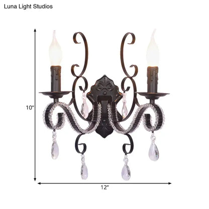 Antique bronze two-light wall mounted lamp with crystal teardrop pendants and candle-style bulbs for living room