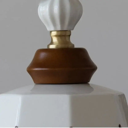 Vintage pendant lights featuring a white ceramic lampshade with a gold-toned metal base and brown wood ceramic accent