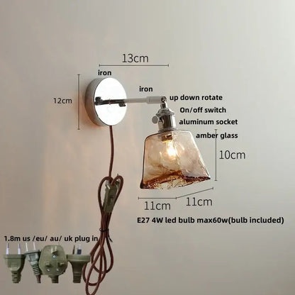 A vintage brushed nickel led wall light with adjustable iron arm and amber glass shade for warm bedroom lighting