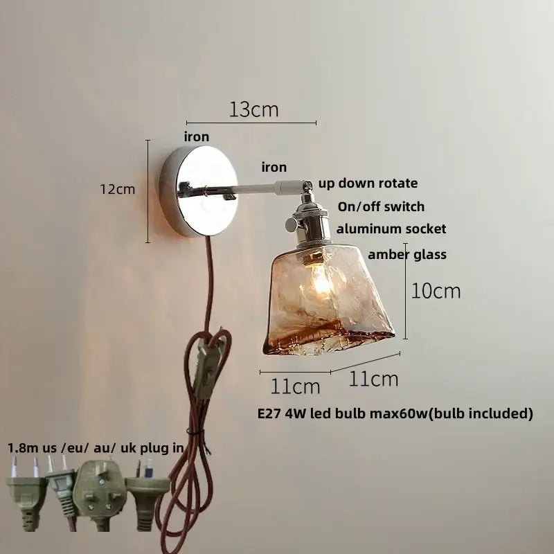 A vintage brushed nickel led wall light with adjustable iron arm and amber glass shade for warm bedroom lighting