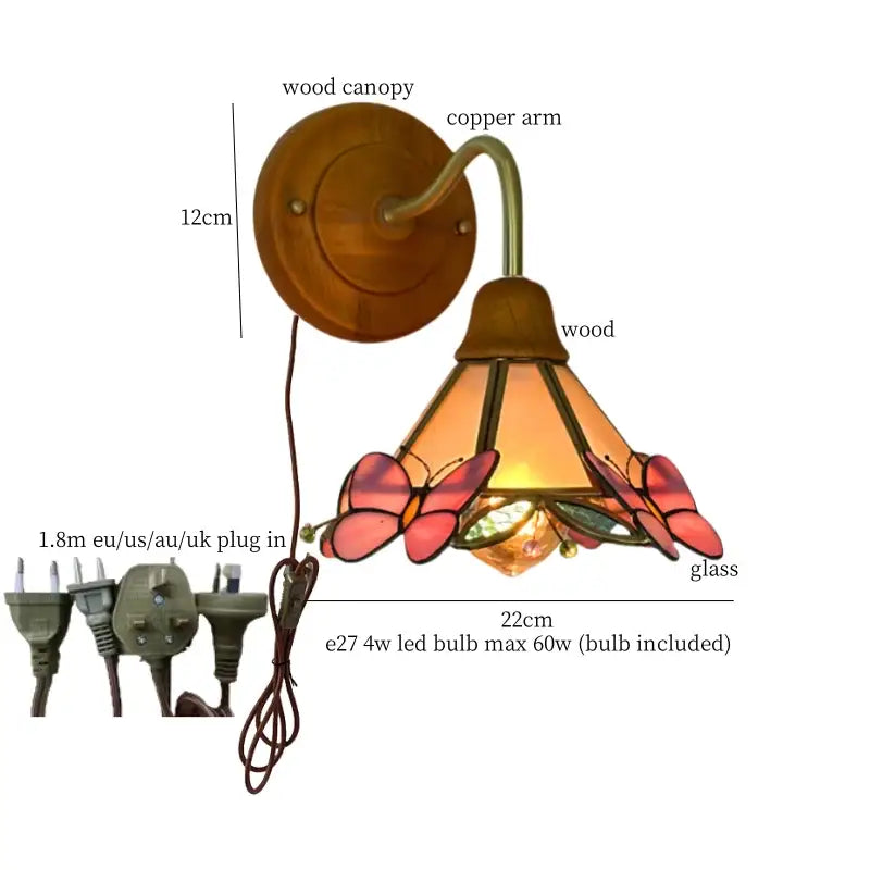 A warm-toned vintage butterfly glass wall light with copper arm and wooden canopy in pink and green decorbites butterfly glass