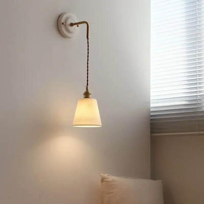 Vintage ceramic and brass wall sconce with cream fabric shade and twisted cord featuring decorbites adjustable led light