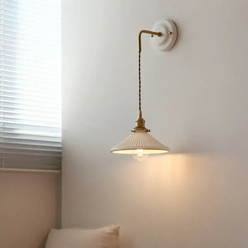 Cream-colored ceramic and brass wall sconce with adjustable led light and metal arm for bedroom decorbites adjustable led use