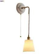 Vintage ceramic and brass wall sconce with adjustable led light, cream base, brass arm, and ribbed off-white shade for bedroom decorbites adjustable led