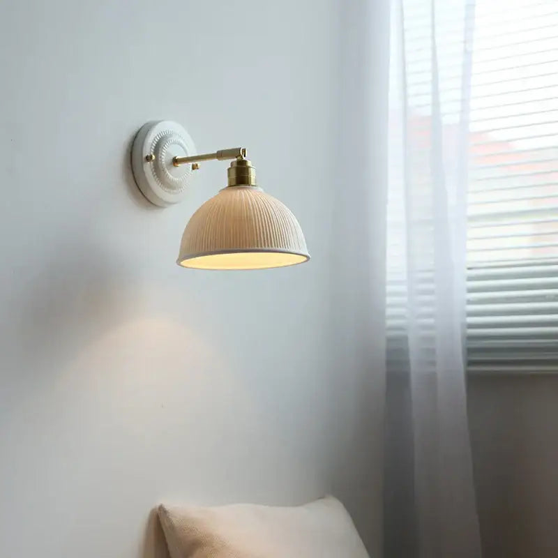Cream-colored ribbed ceramic wall lamp with brass-finished arm by decorbites for vintage bedroom decorbites ceramic wall lamp
