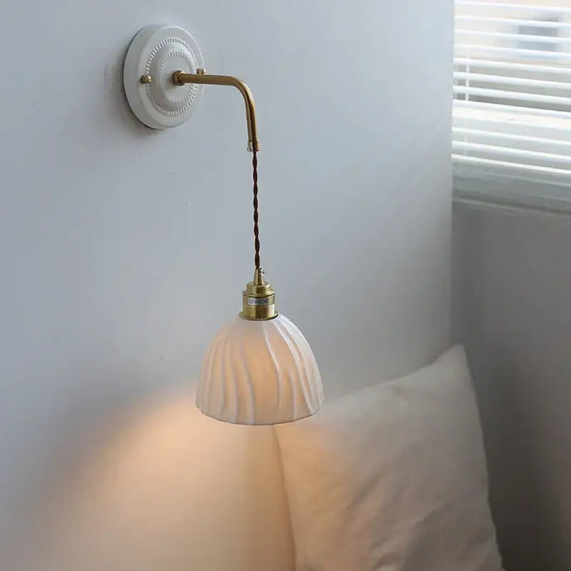 White ribbed glass pendant lamp with brass arm complements vintage ceramic wall sconce for elegant bedroom decorbites ceramic wall lighting