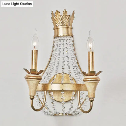 Gold-finished crown-themed wall light with champagne finish and clear crystal accents for elegant living room decor