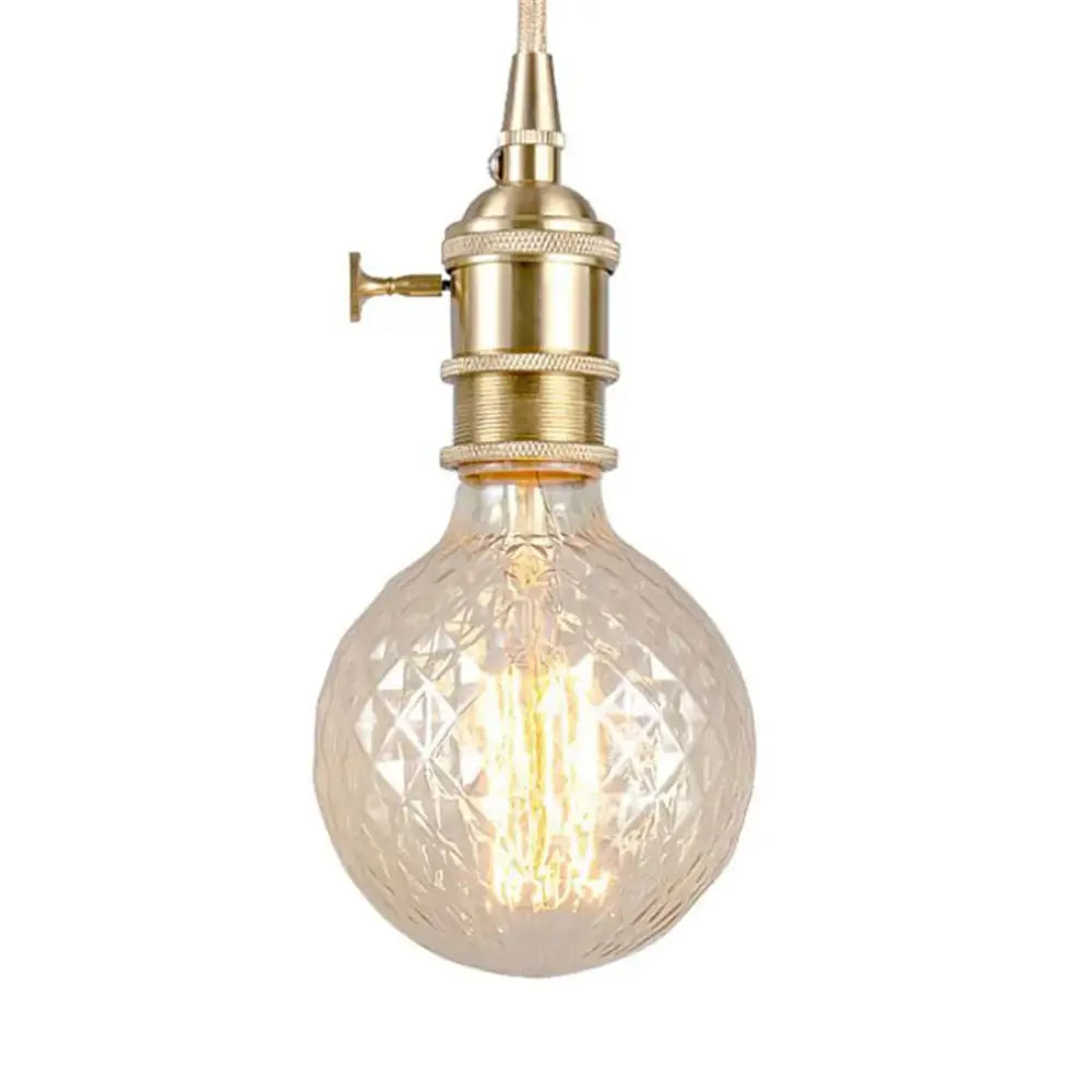 A warm-toned vintage clear faceted globe edison bulb with brass socket and filament for living room light dimmable 4w led