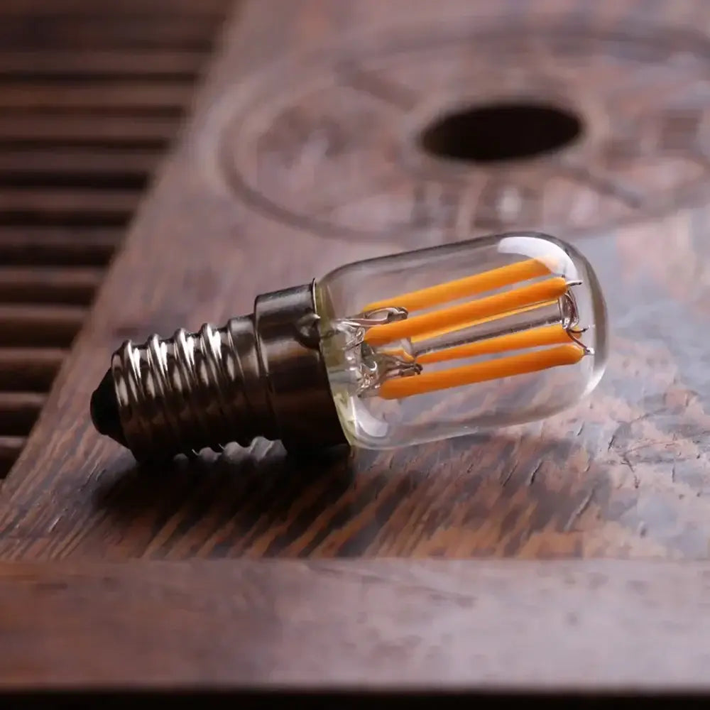 Vintage clear glass led tubular bulb with metallic screw base and three glowing orange filaments, dimmable e12 e14 light
