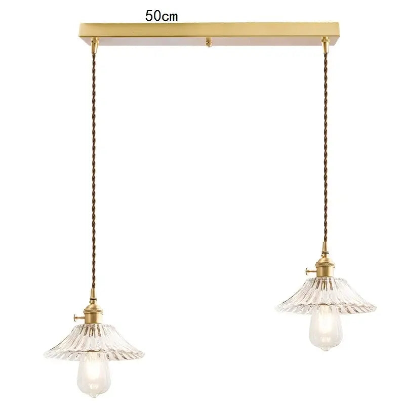 A pair of elegant brass pendant lights with clear fluted glass shades and twisted cords in a kitchen decorbites glass lamp fixture