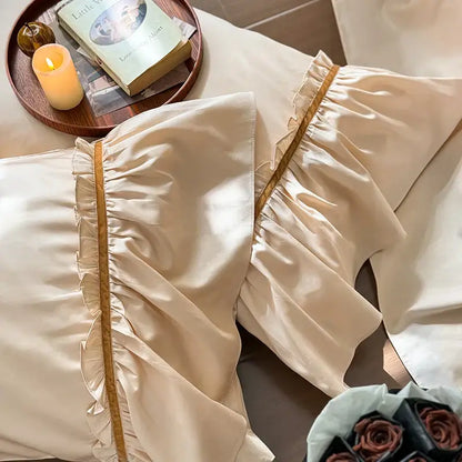 Cream-colored satin pillowcases with ruffled edges and gold trim from vintage cream and gold decorbites 100s cotton bedding set