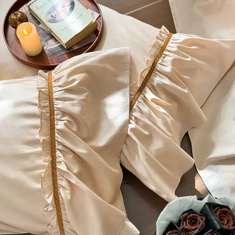 Cream-colored satin pillowcases with ruffled edges and gold trim from vintage cream and gold decorbites 100s cotton bedding set