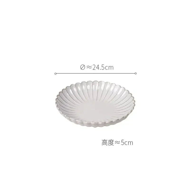 A white ceramic dish with a scalloped rim and ridges from a vintage cream scalloped dining table set