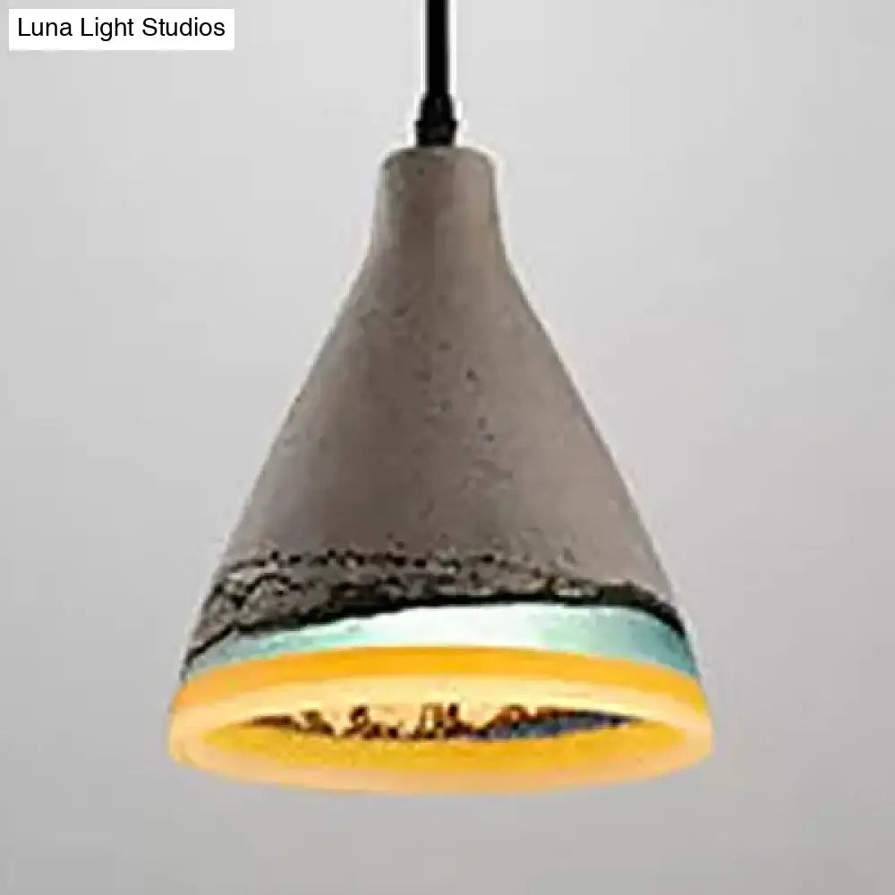 Decorbites mélodie pendant light with textured gray concrete body and layered dark blue and light blue bands near base