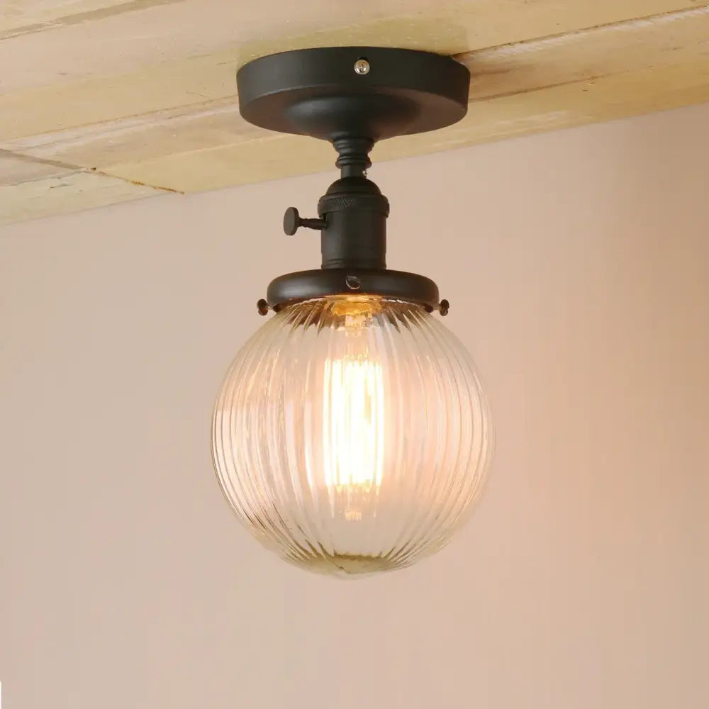 Vintage dark bronze semi flush mount ceiling light with black metal fixture and clear ribbed glass globe for bedroom