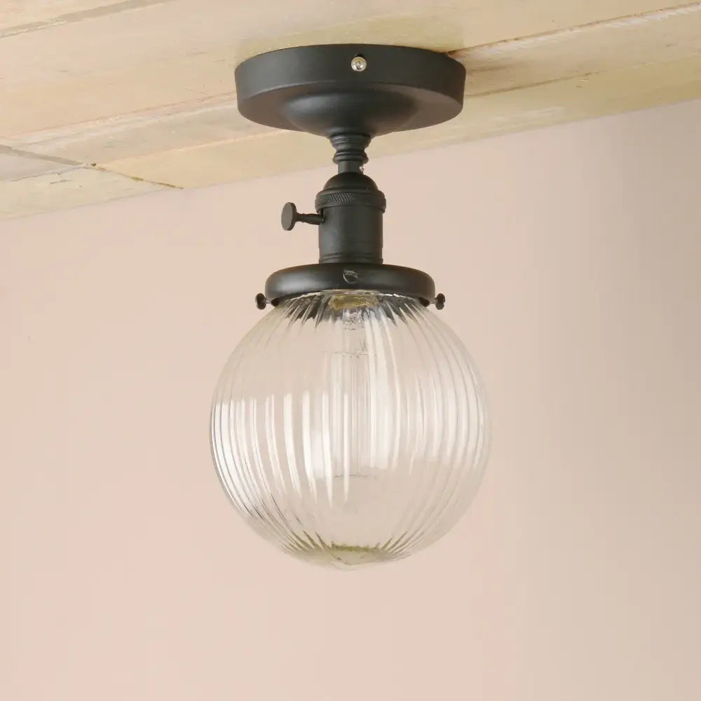 Vintage dark bronze semi flush mount ceiling light with black metal fixture and clear ribbed glass globe for bedroom