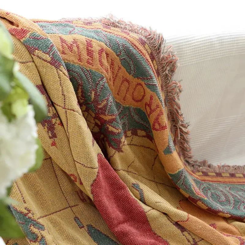Vintage earth tone world map bohemian cotton plaid sofa blanket in mustard yellow with intricate patterns and frayed edges