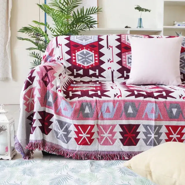 A cozy decorbites bohemian cotton plaid sofa blanket with multicolored geometric pattern and fringed edge