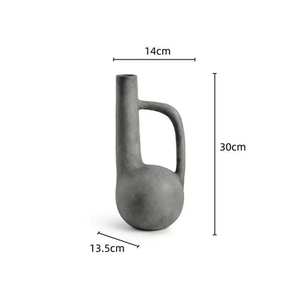 A matte gray ceramic decorbites geometric stoneware vase with a rounded base and integrated handle for living room decor