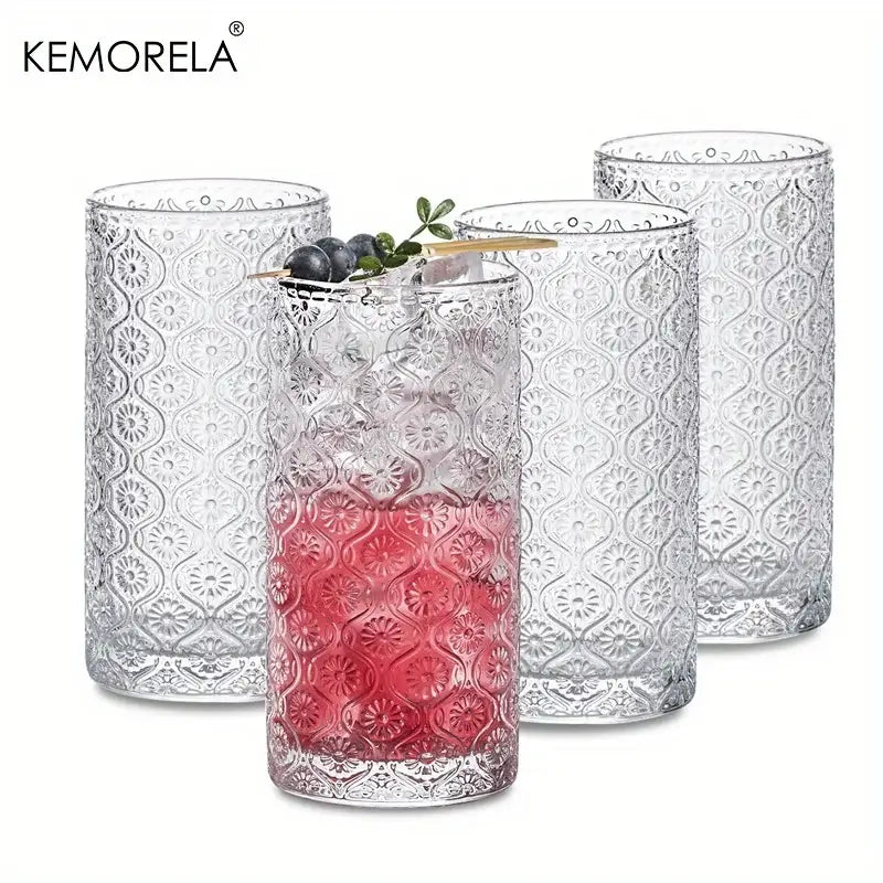 Clear glass vintage glassware tumblers with embossed floral pattern and pink liquid in a blue red and gold set