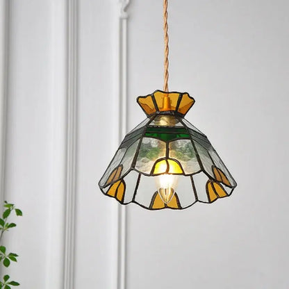 Vintage floral stained glass brass pendant lamp with yellow and green floral design hanging from twisted copper cord