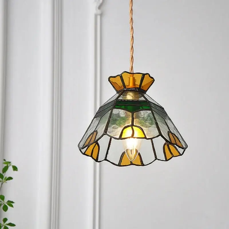 Vintage floral stained glass brass pendant lamp with yellow and green floral design hanging from twisted copper cord