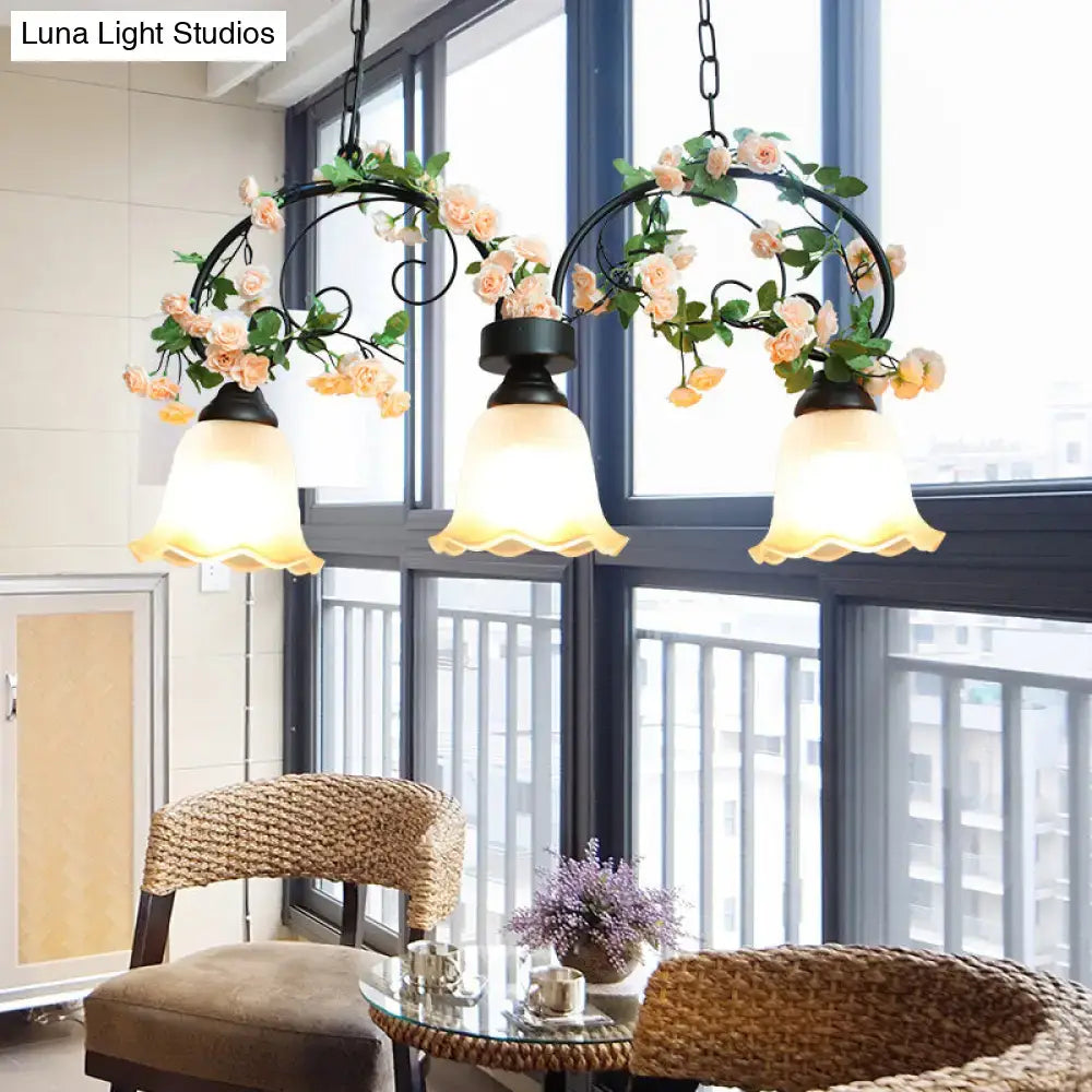 Black wrought iron DecorBites™ white glass island light with three frosted shades and decorative peach floral vines for rose restaurant suspension