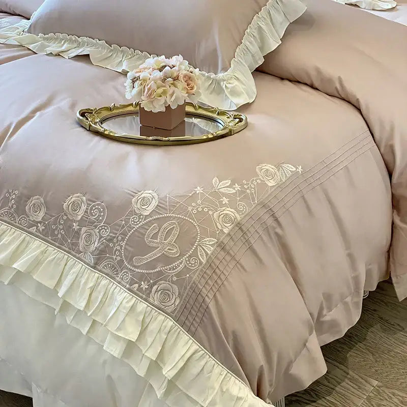 Beige satin duvet cover with delicate white floral embroidery and vintage french ruffles in a bedding set