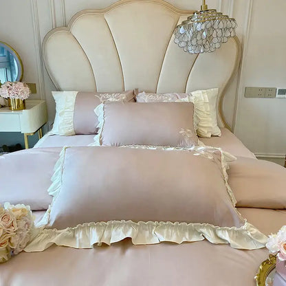 A soft blush pink satin pillowcase with cream vintage french ruffles and floral embroidery from bedding set