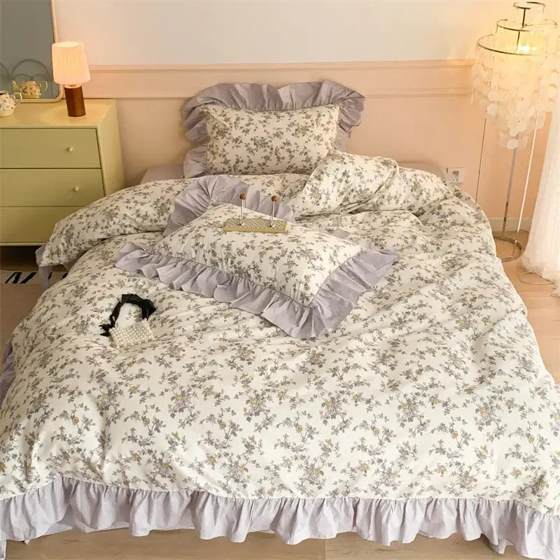 A soft cream-colored french floral cotton bedding set with delicate gray patterns and matching ruffled edges by decorbites