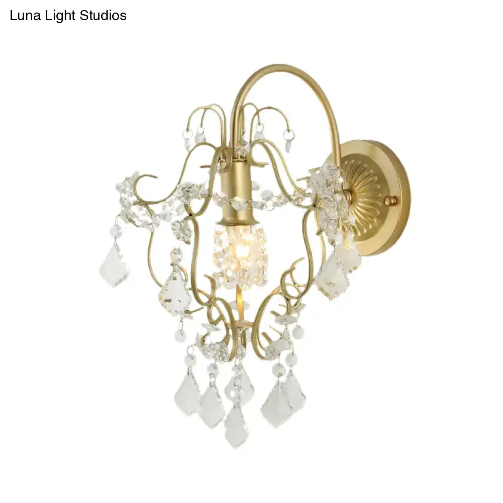 Vintage wall lamp with gold finish featuring intricate filigree and clear crystal droplets for bedroom lighting
