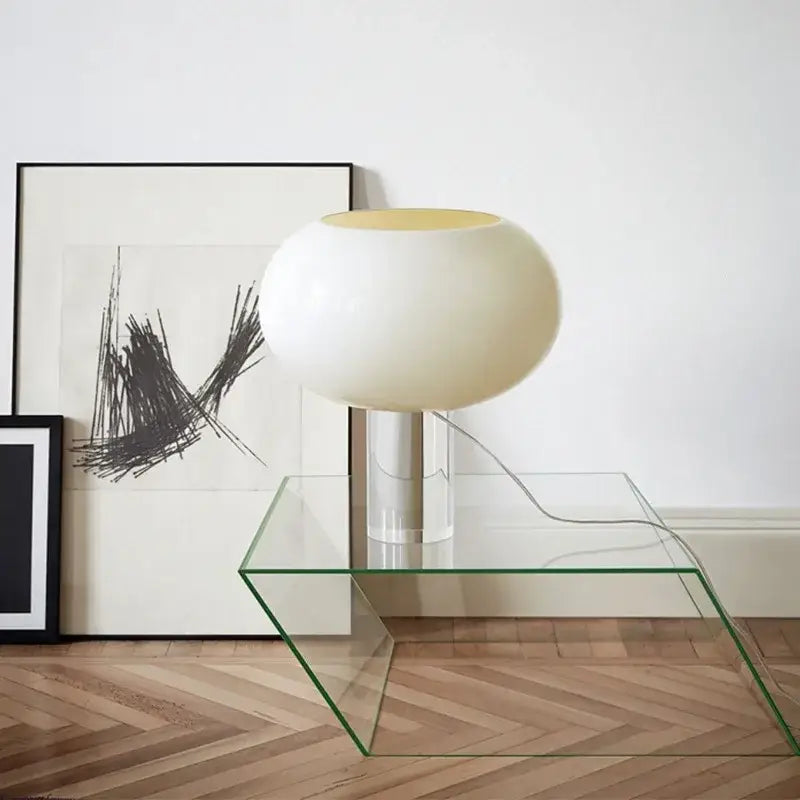 Cream-colored glossy globe table lamp with metallic stem on glass table for warm bedroom decorbites buds table lamp