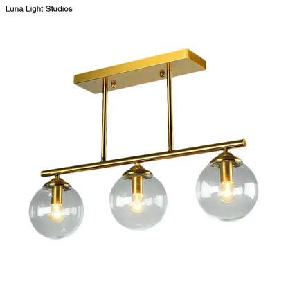 Gold-toned DecorBites vintage 3-bulb pendant lamp with clear amber glass sphere shades and brass metal arms for island lighting