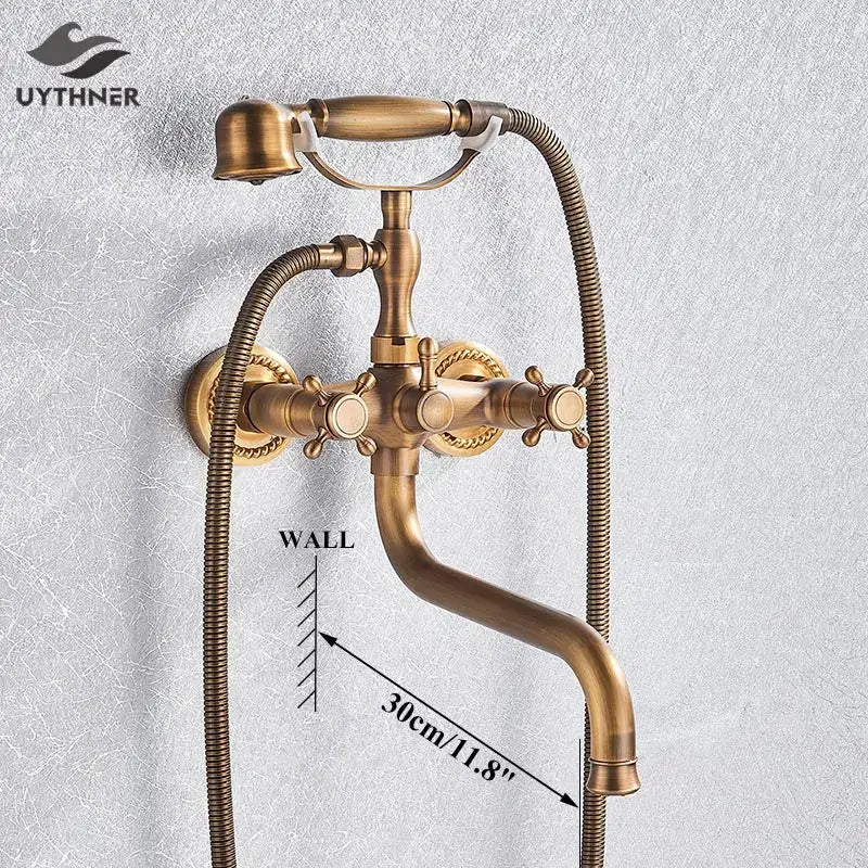 Antique brass vintage-style wall-mounted bathtub faucet with ornate handles and flexible hoses in golden black decorbites finish