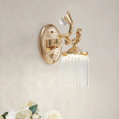 Vintage gold wall mounted light with clear pipe prisms and ornate curved arms for elegant bedroom lighting