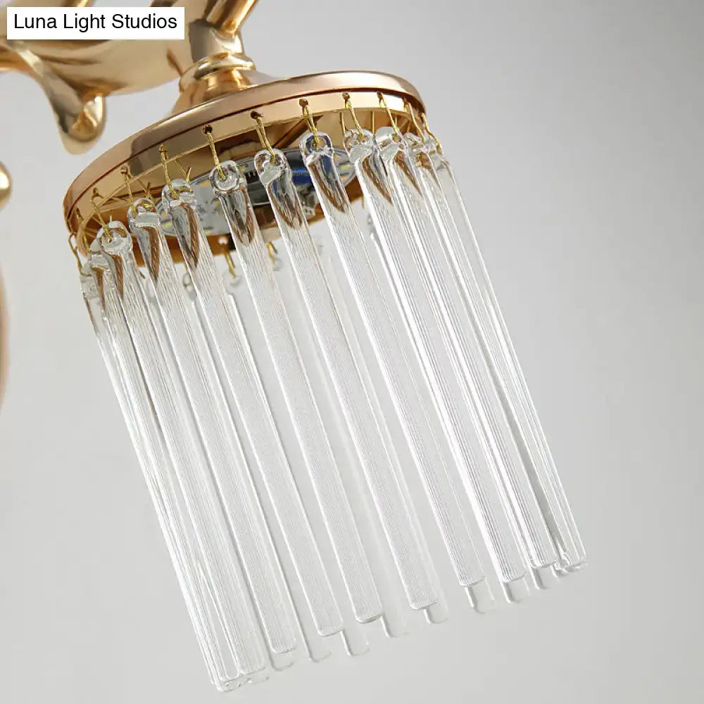 Vintage gold wall mounted light with clear pipe crystal prisms hanging from a circular brass frame