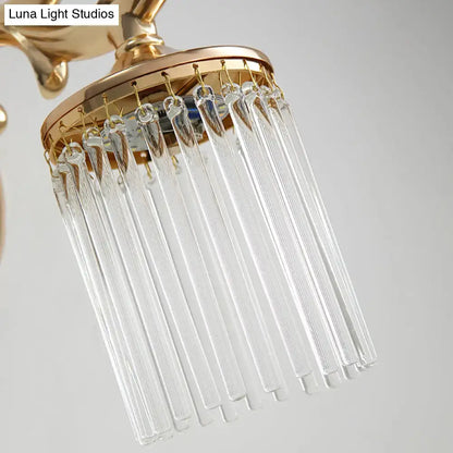 Vintage gold wall mounted light with clear pipe crystal prisms hanging from a circular brass frame
