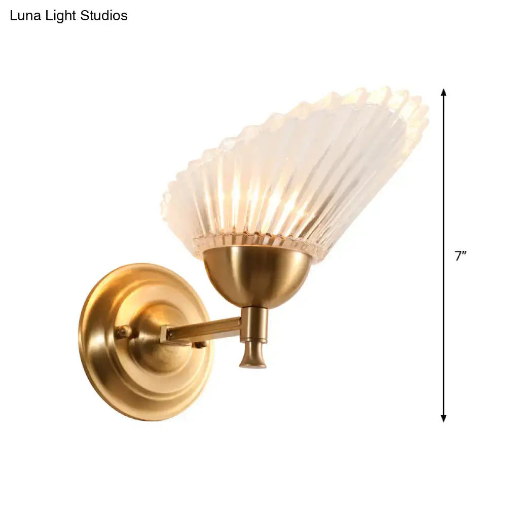 Vintage gold finish wall lamp with a brass shell base and frosted fluted glass shade for bedroom lighting