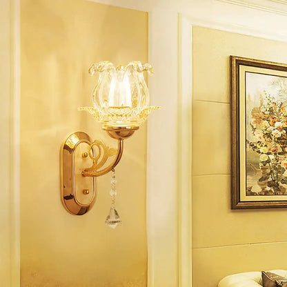 Vintage gold flower wall sconce with amber glass shade and pull chain featuring a clear hand-blown flower design